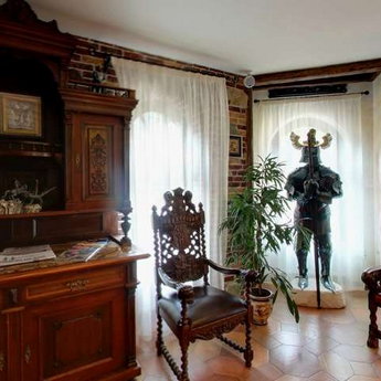 Chimney hall in the hotel Vezha Vedmezha, armor and medieval-style chairs