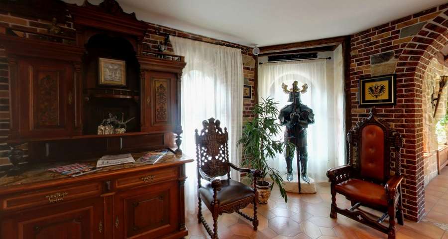Chimney hall in the hotel Vezha Vedmezha, armor and medieval-style chairs